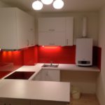 kleine weiße Wohnküche mit roter Nischenrückwand