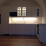 weiße Küche in Rundbogen des Schlosszimmers perfekt integriert