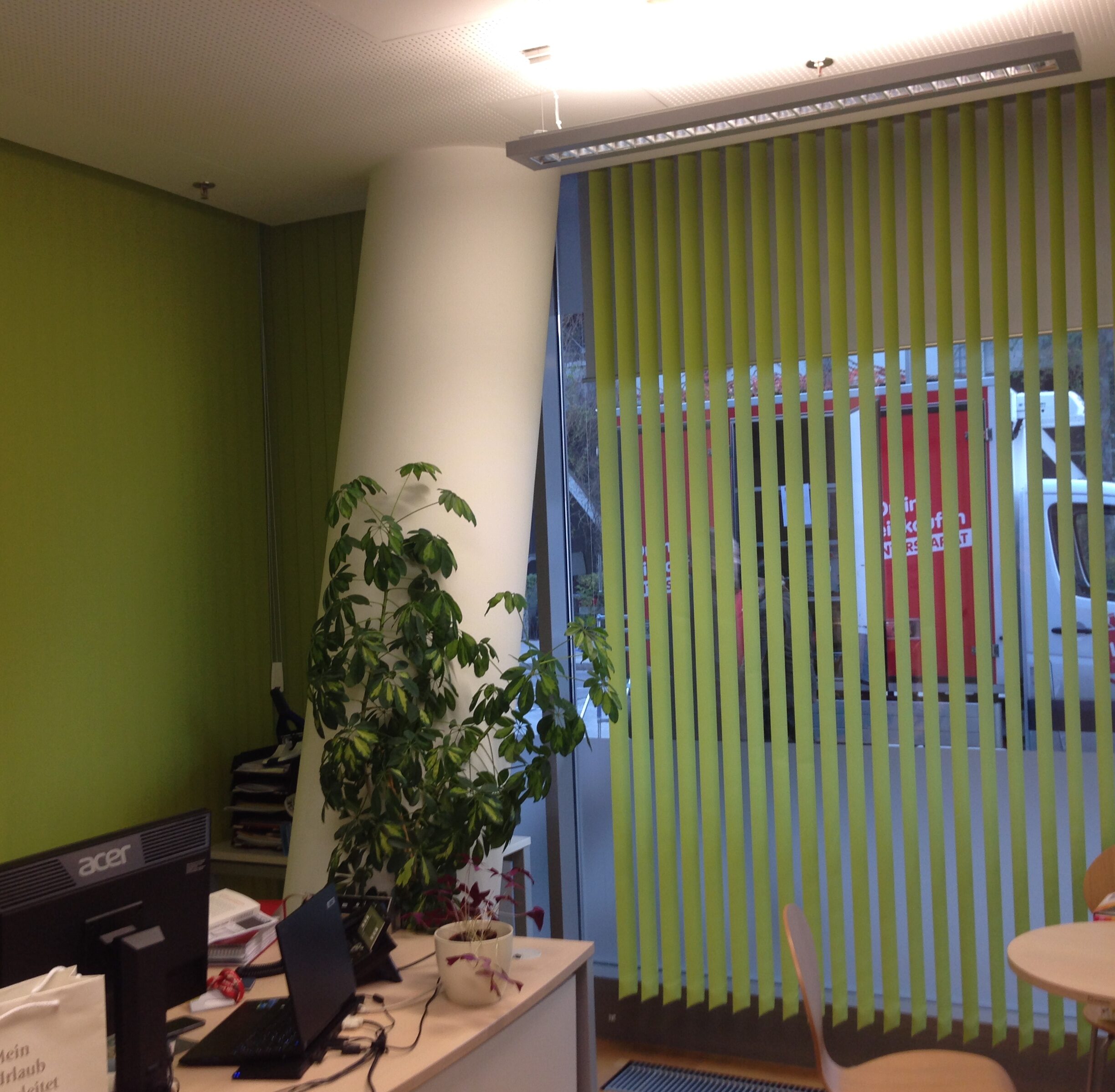 Die grüne Vertikaljalousie setzt das Büro farblich in Szene.